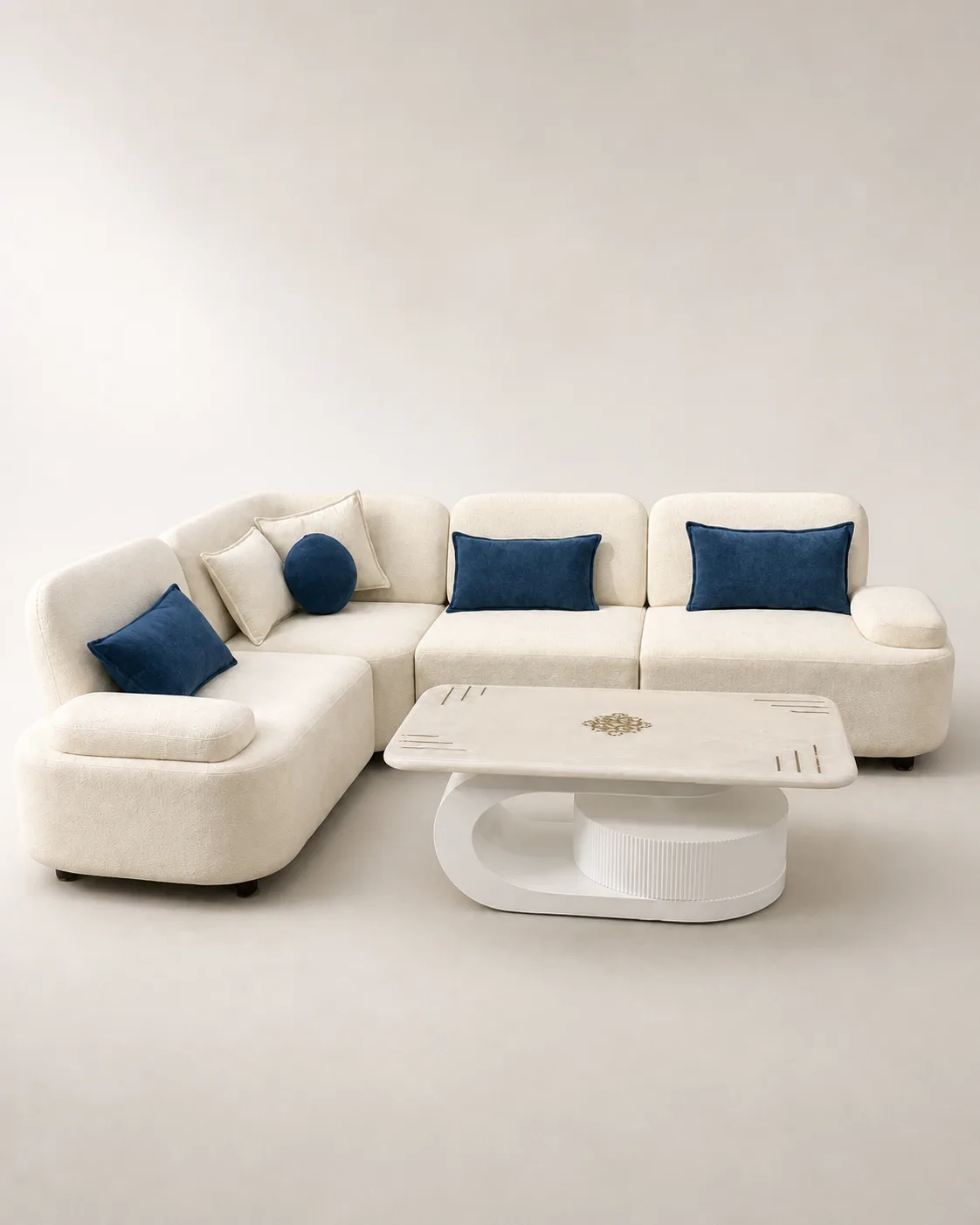 Cream boucle sofa with navy blue accent cushions and marble pedestal table.