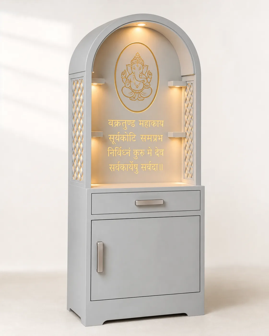Grey mandir unit with a rounded arch top, backlit Ganesh medallion and Vakratunda mantra panel.