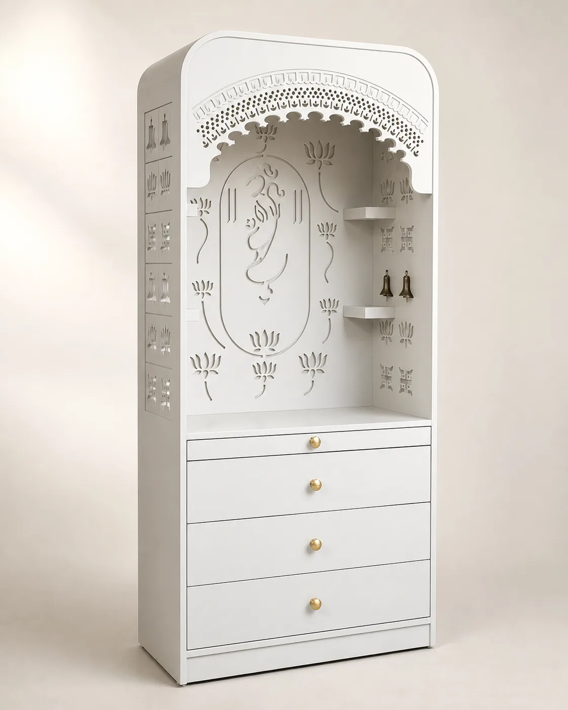 Minimal white mandir unit with a fine Ganesh outline carving and corner shelves.