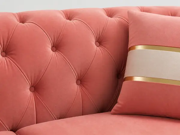 Close-up of diamond tufting detail on coral pink sofa