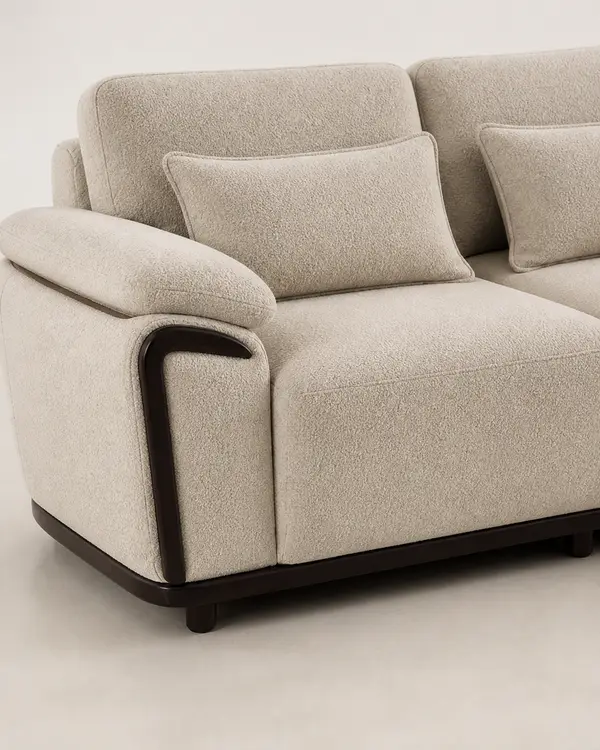 Close-up of curved wood arm detail on taupe boucle sofa
