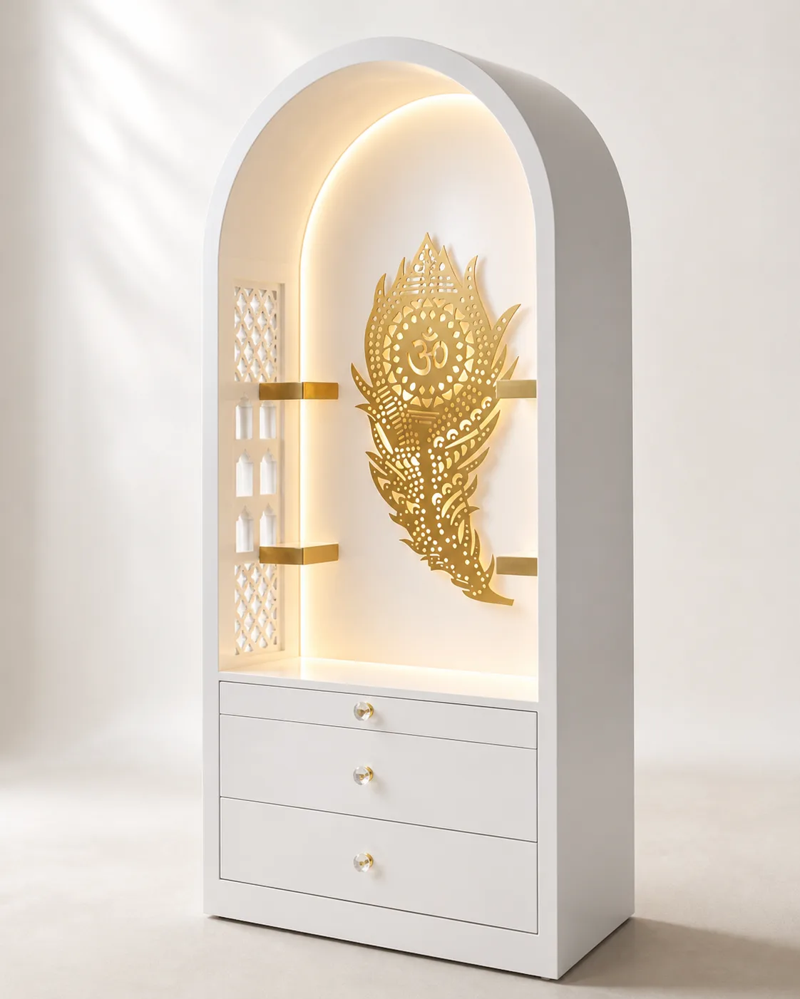 White mandir unit with a rounded arch, gold peacock feather motif and hidden cove lighting.